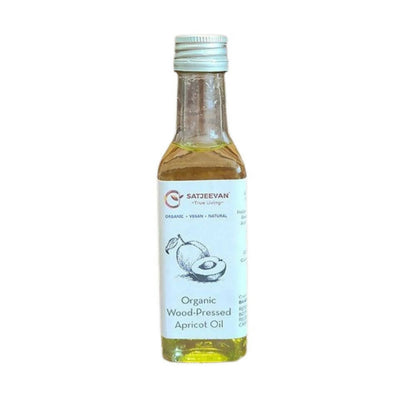 Bottle of organic wood-pressed apricot oil with a white label on a white background