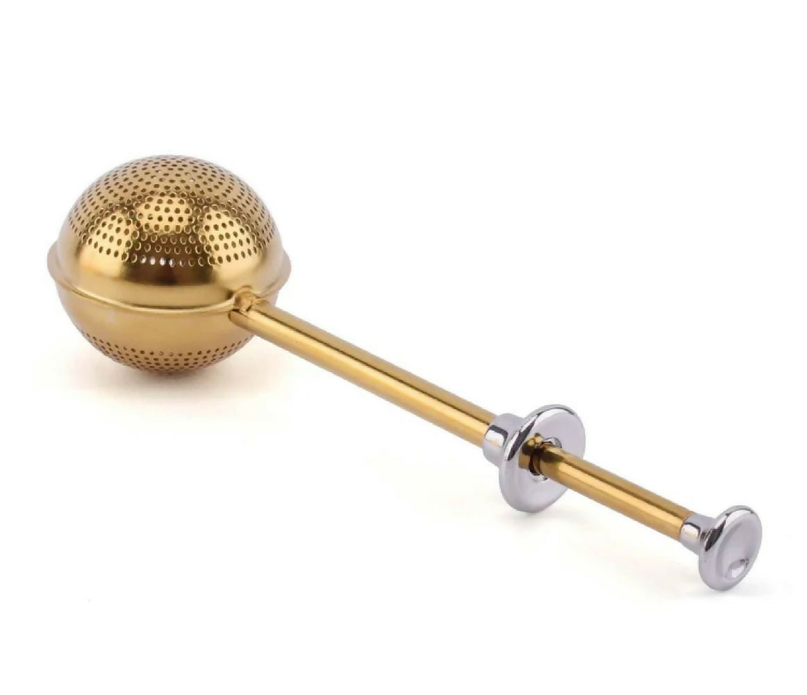 Gold and silver tea infuser on a white background