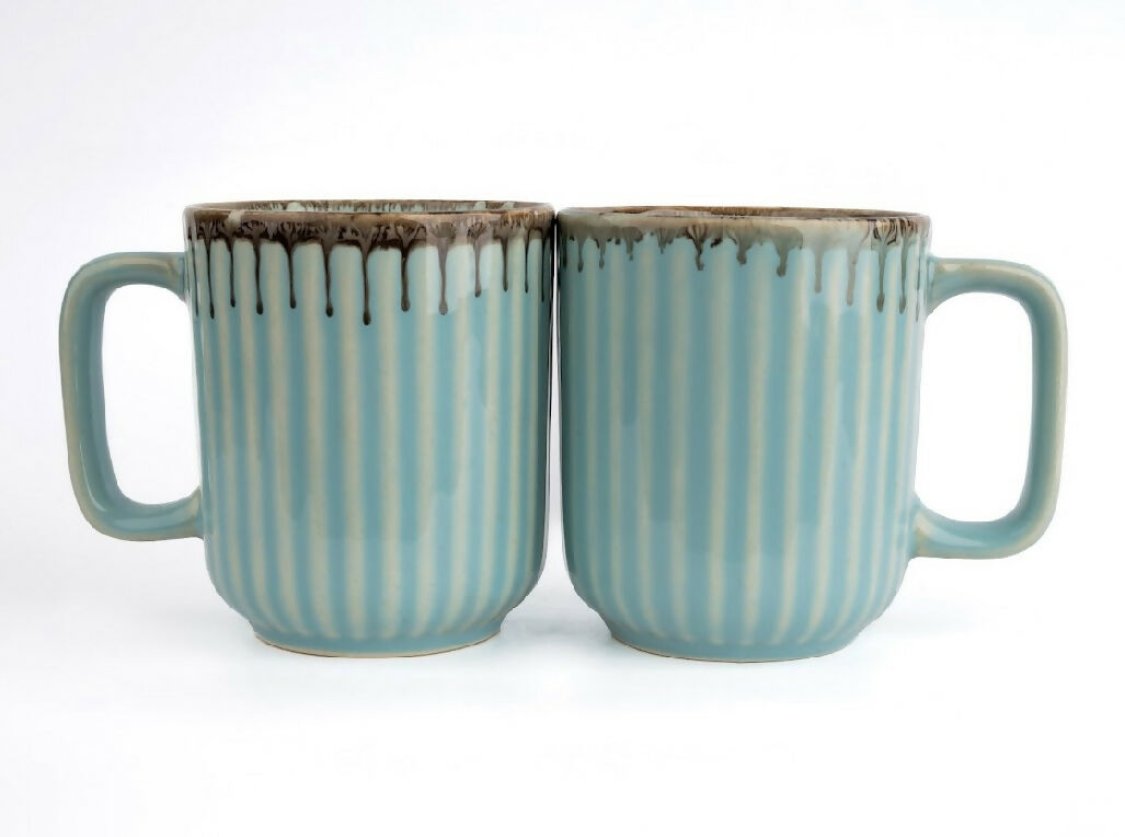 Two ceramic mugs with striped design on a white background