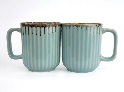 Two ceramic mugs with striped design on a white background