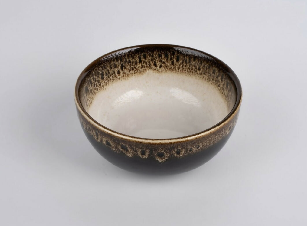 Ceramic bowl with speckled brown exterior on a light gray background
