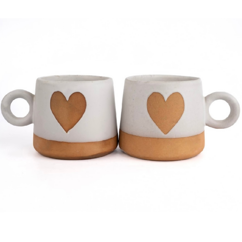Two ceramic mugs with heart designs on a white background