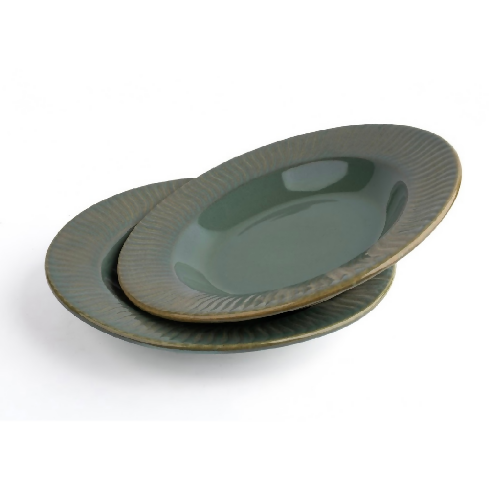 Set of three green ceramic plates stacked on a white background