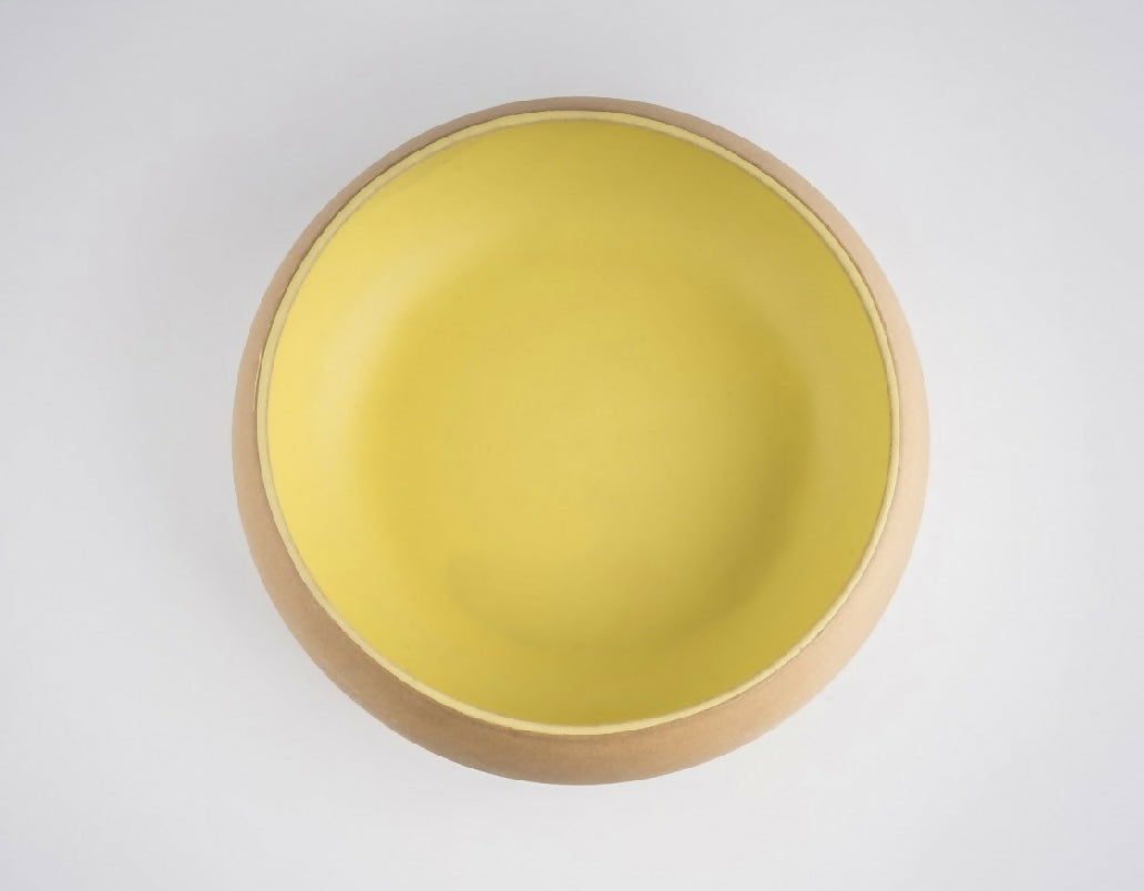 Yellow bowl with wooden rim on a white background