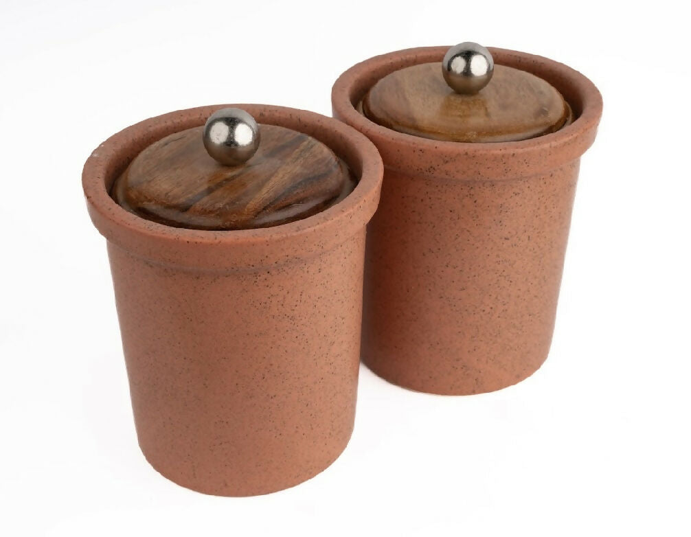 Two terracotta pots with wooden lids on a white background
