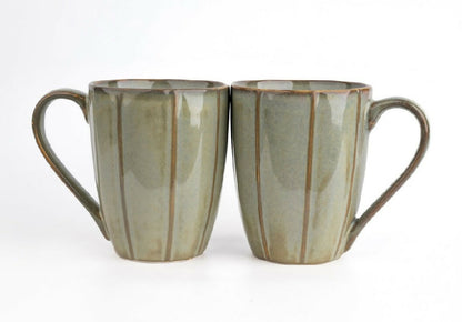 Two ceramic mugs with striped design on a white background