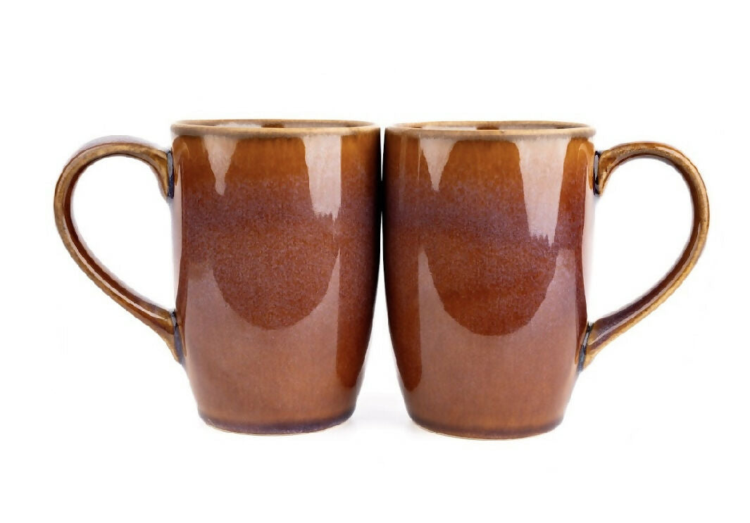 Two brown ceramic mugs with handles on a white background