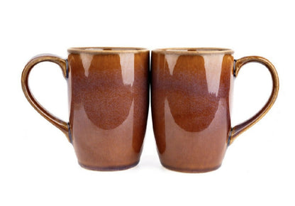 Two brown ceramic mugs with handles on a white background