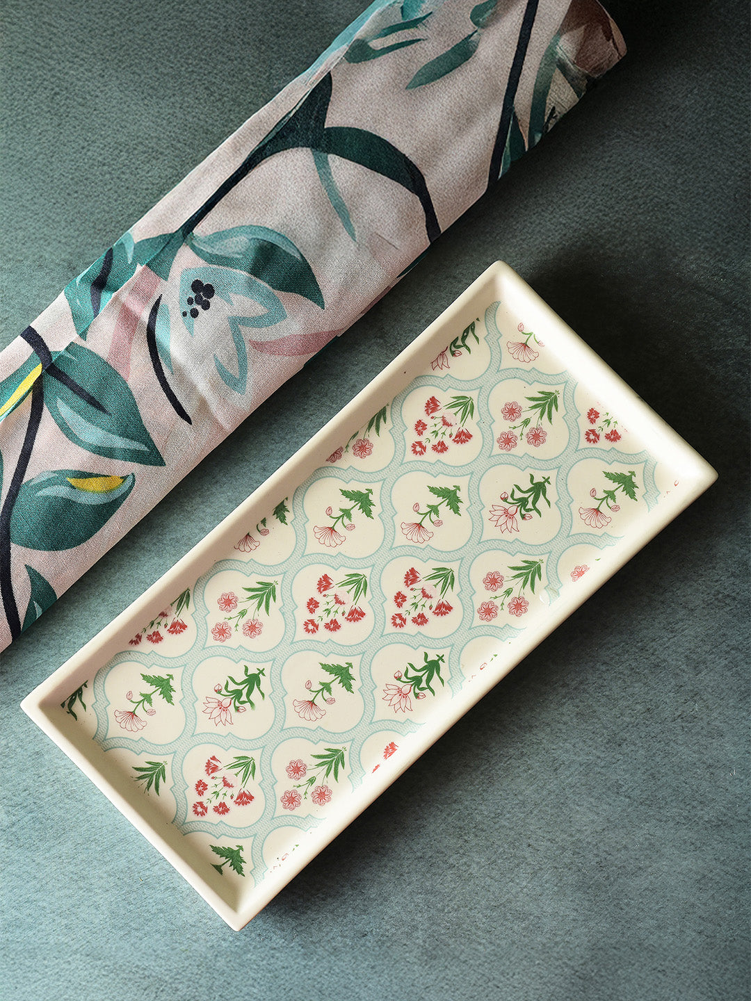 Rectangular ceramic tray with floral pattern on a dark surface