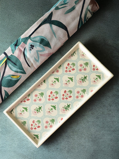 Rectangular ceramic tray with floral pattern on a dark surface