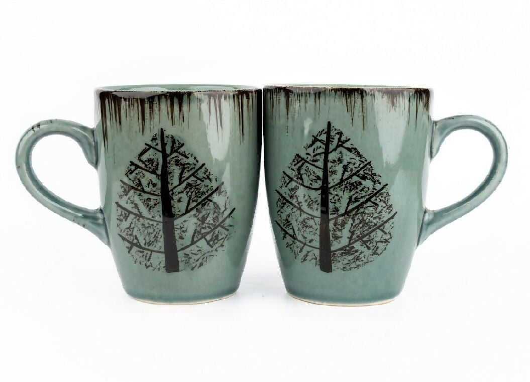 Two ceramic mugs with tree design on a white background