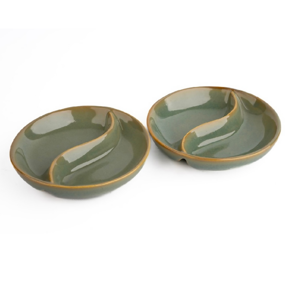 Two green ceramic bowls with wavy edges on a white background