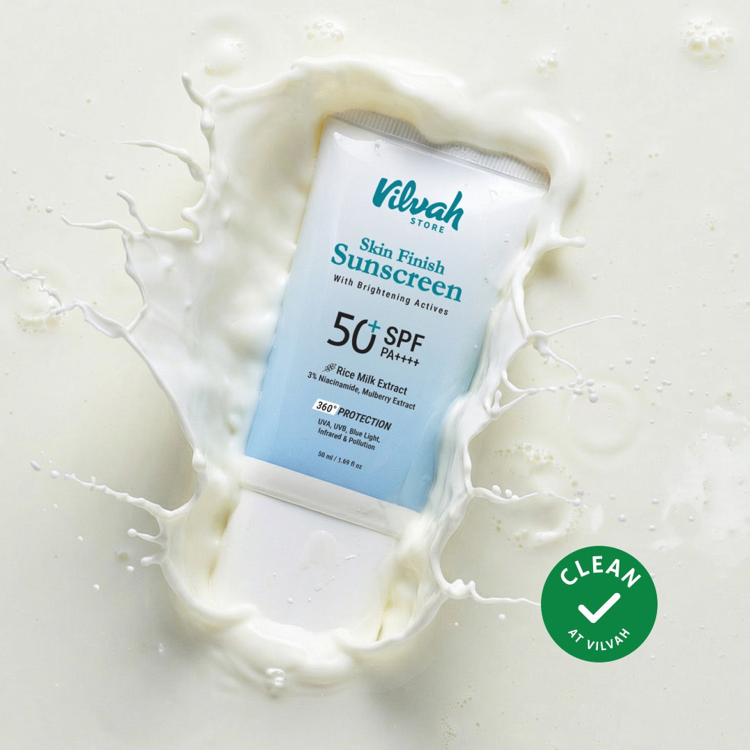 Vilvah Skin Finish Sunscreen tube with milk splash on a light background