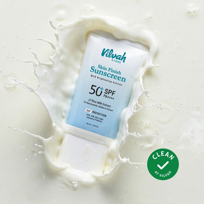 Vilvah Skin Finish Sunscreen tube with milk splash on a light background