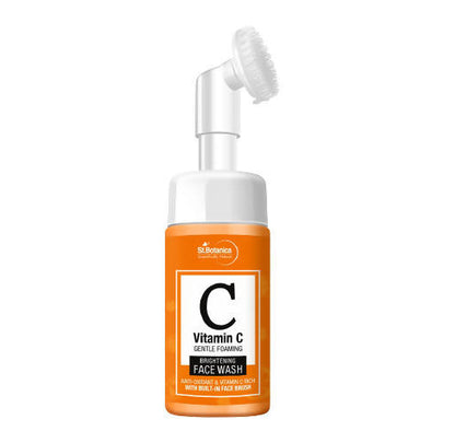 Orange bottle of Vitamin C face wash with a brush on a white background