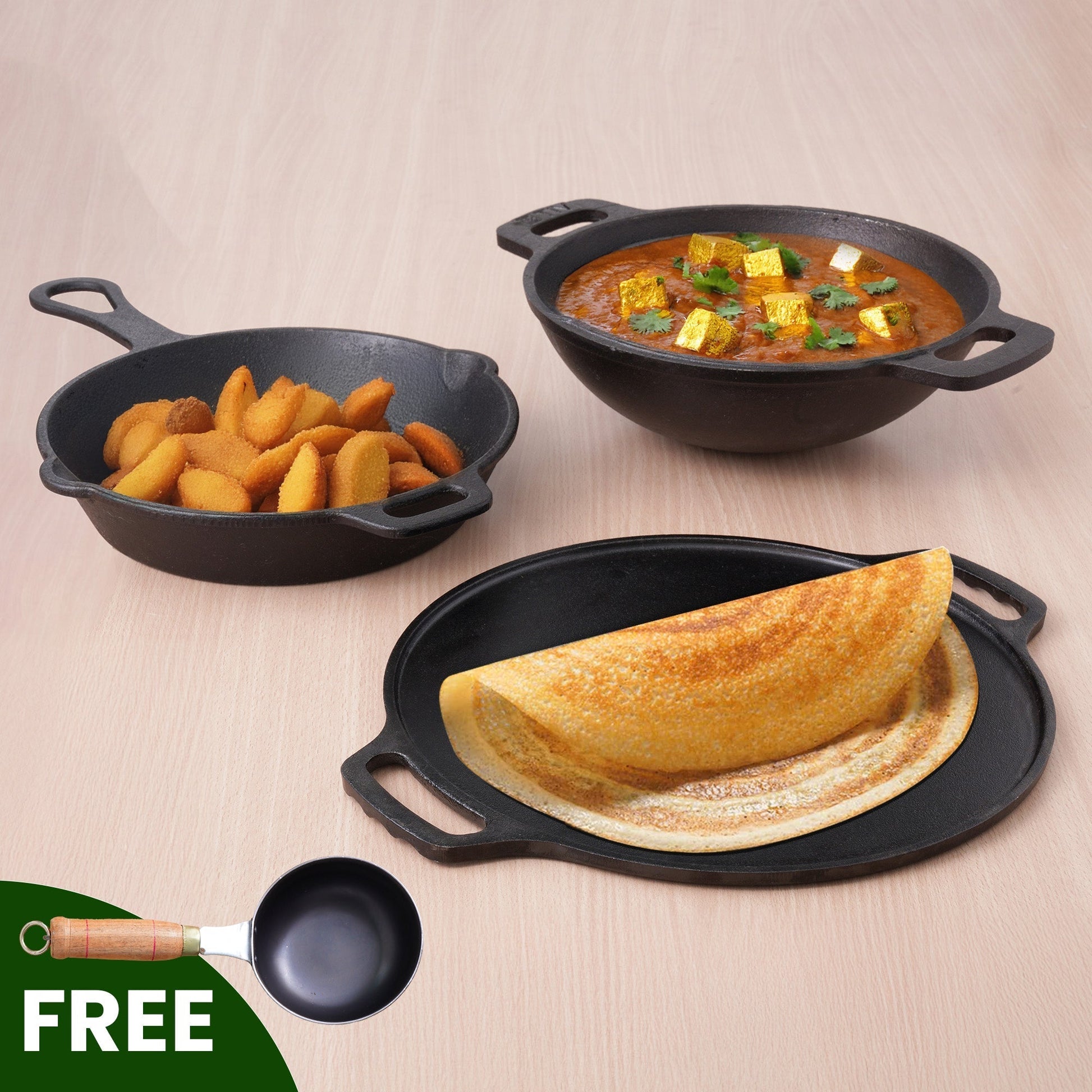 Three black cast iron skillets with food on a beige background