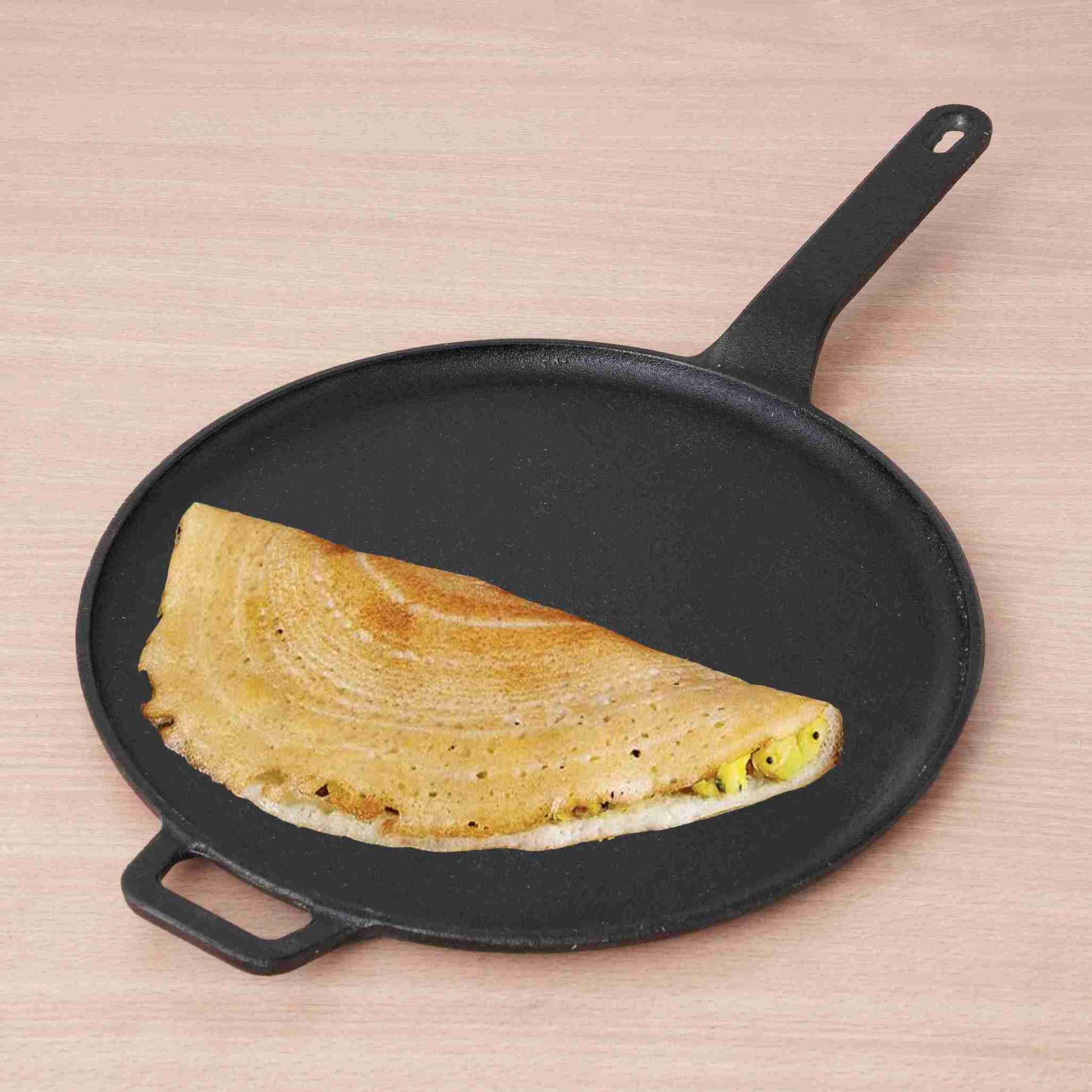 Omelette on a cast iron pan with a pink background
