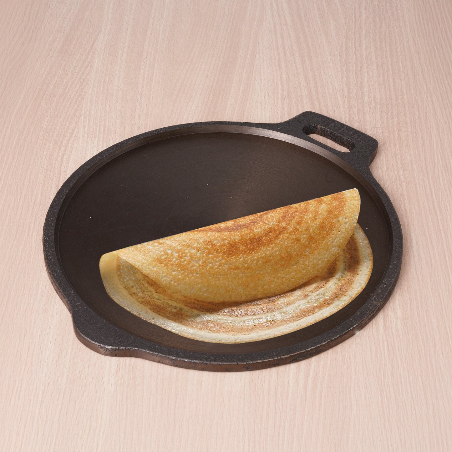 Folded omelette on a cast iron skillet with a wooden background