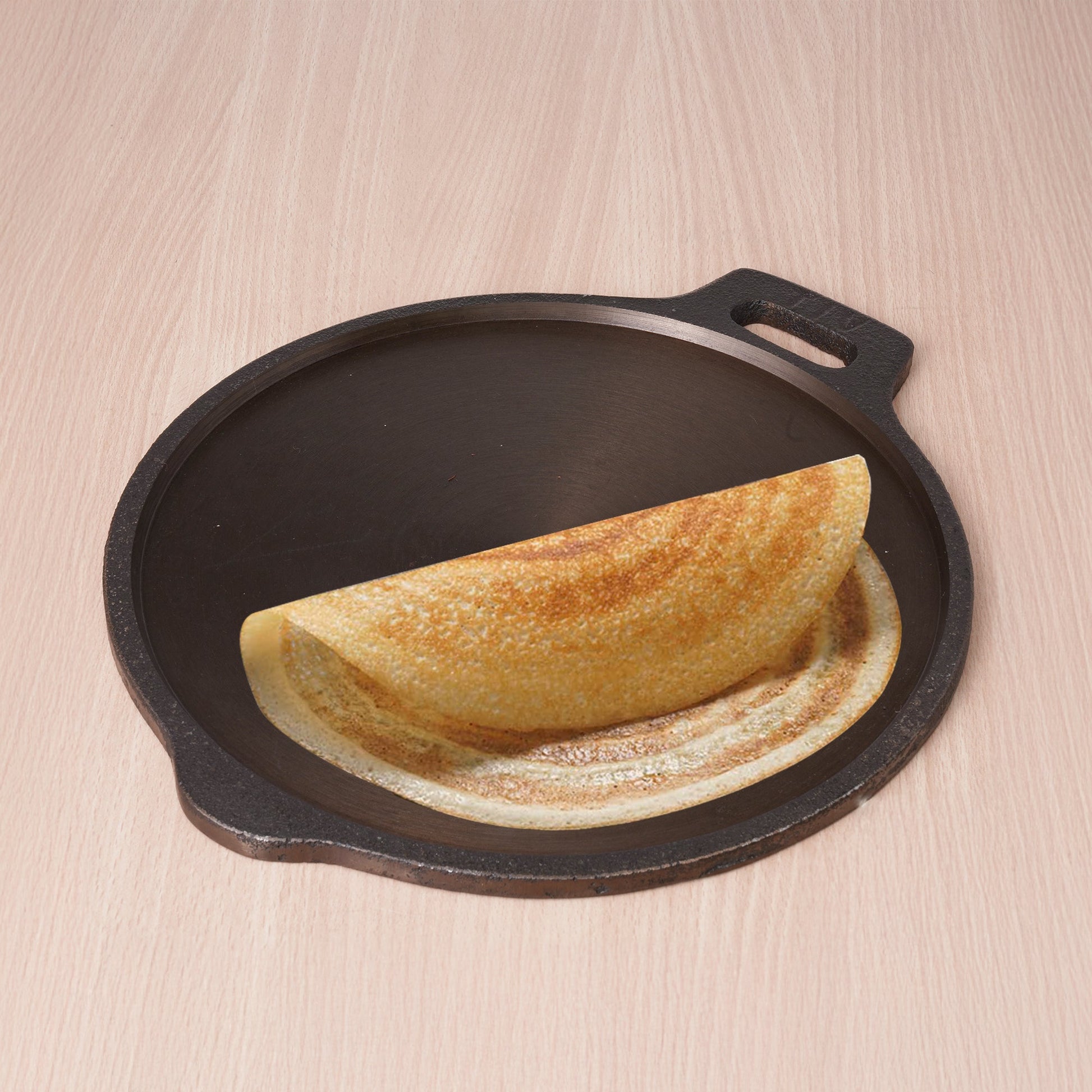 Folded omelette on a cast iron skillet with a wooden background