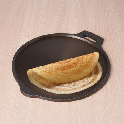 Folded omelette on a cast iron skillet with a wooden background