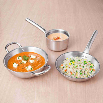 Three stainless steel cookware items on a beige background