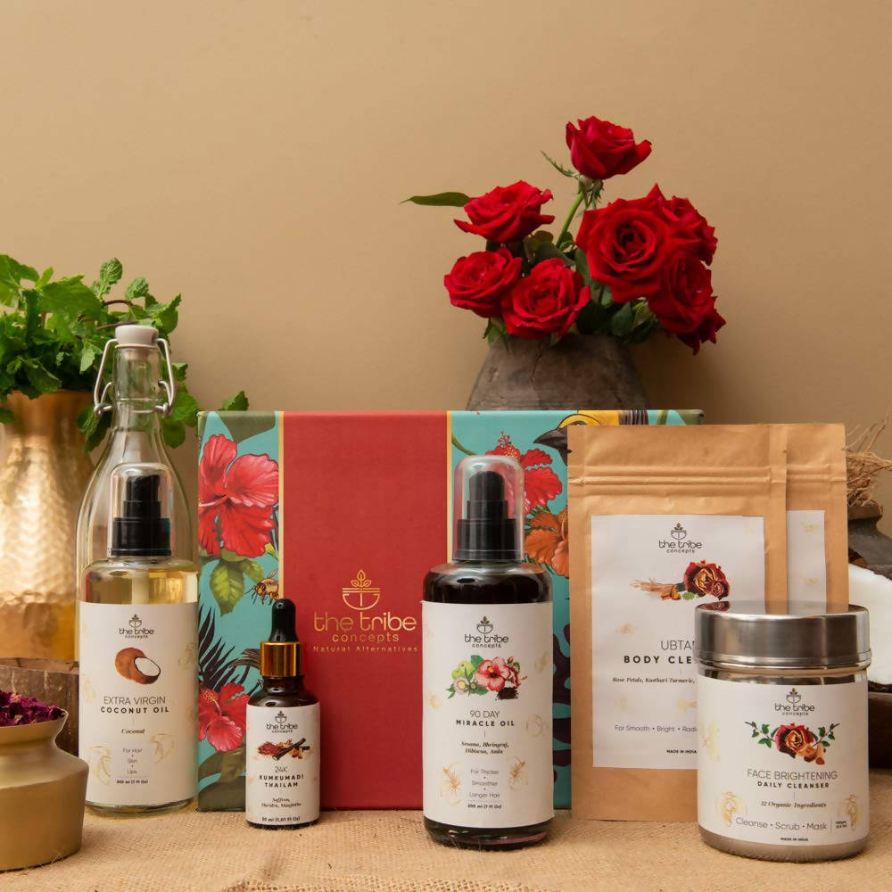 Collection of skincare and wellness products with red roses in the background on a beige surface.