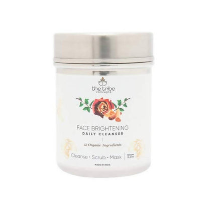 A tin container of The Tribe Concepts Face Brightening Daily Cleanser with a label showing the product name and a rose illustration. The product is designed to cleanse, scrub, and mask the skin.