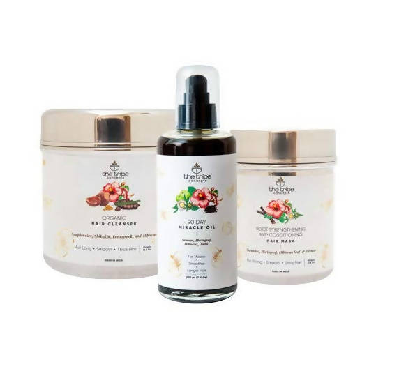 A set of three hair care products from The Tribe Concepts, including a bottle of hair oil, a jar of hair cleanser, and a hair mask, all with labels and caps visible.