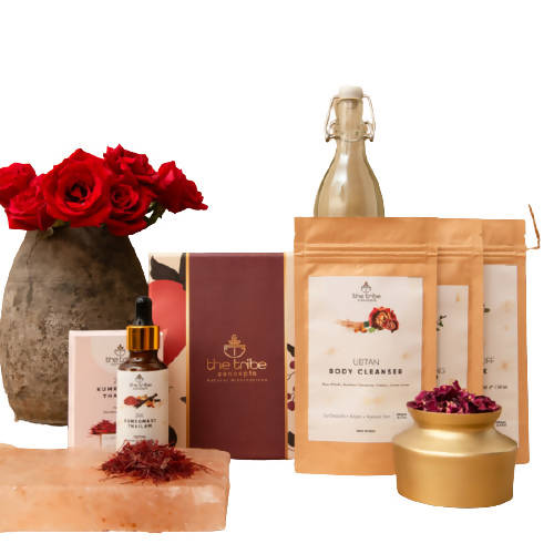 Collection of skincare and wellness products with a vase of red roses on a white background