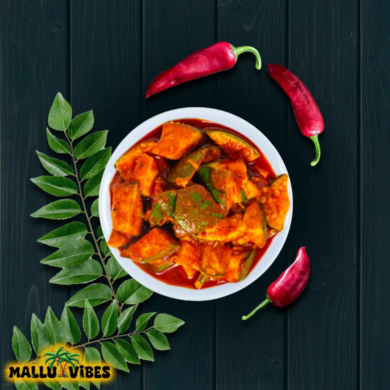  bowl of curry with red peppers and green leaves on a dark background, featuring the 'Mallu Vibes' logo.