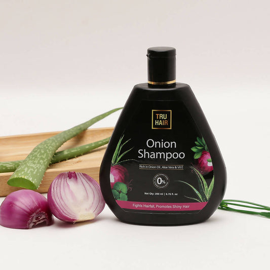 Tru Hair Onion Shampoo bottle with onions and green leaves on a light background