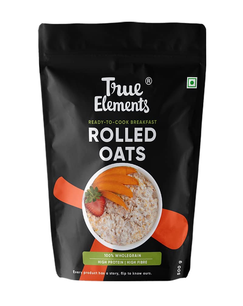 Bag of True Elements rolled oats with a bowl of oats and strawberries on a black background