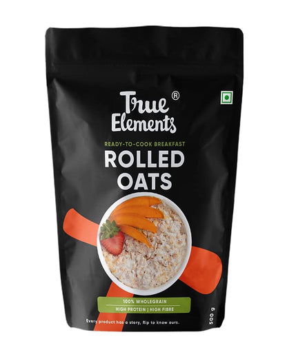 Bag of True Elements rolled oats with a bowl of oats and strawberries on a black background