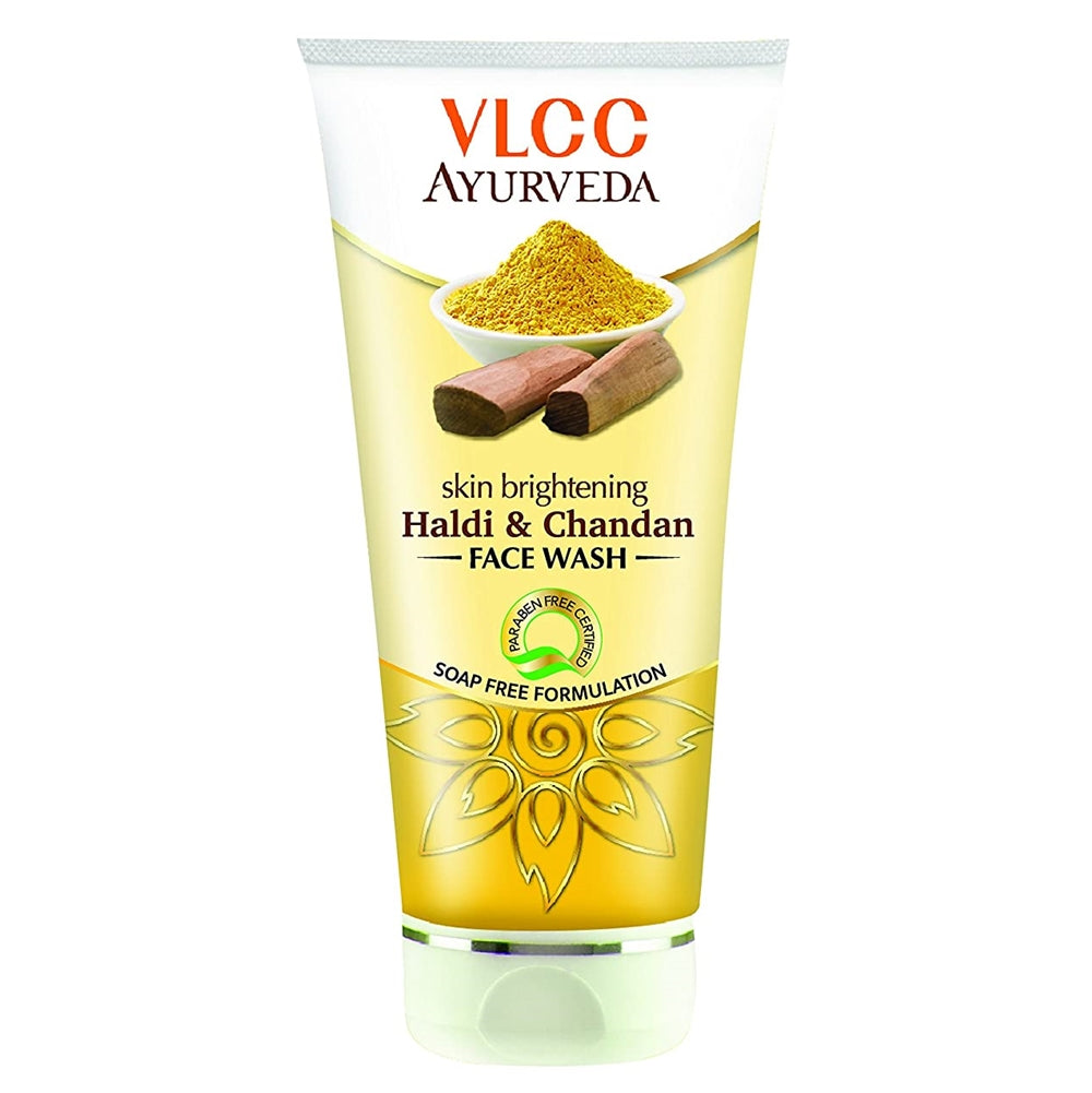 A plastic tube of VLCC Ayurveda skin brightening face wash with Haldi & Chandan. The packaging is chrome yellow with an illustration of turmeric and sandalwood and text detailing the product name and benefits.