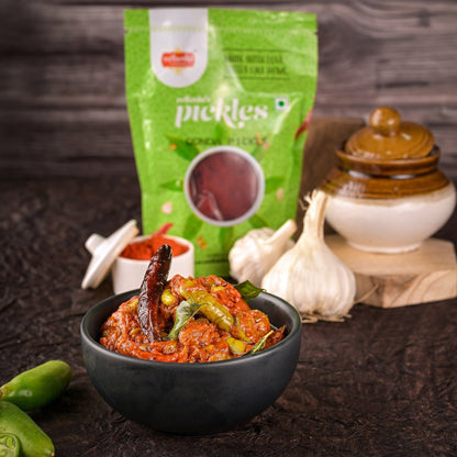 Bowl of pickles with a green packet labeled 'pickles' in the background.