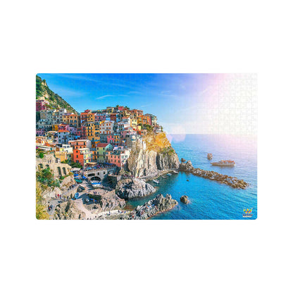 Colorful coastal town built into a cliffside with blue sea and sky.