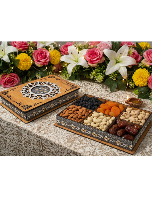 Decorative box with assorted dried fruits and nuts on a table with flowers in the background