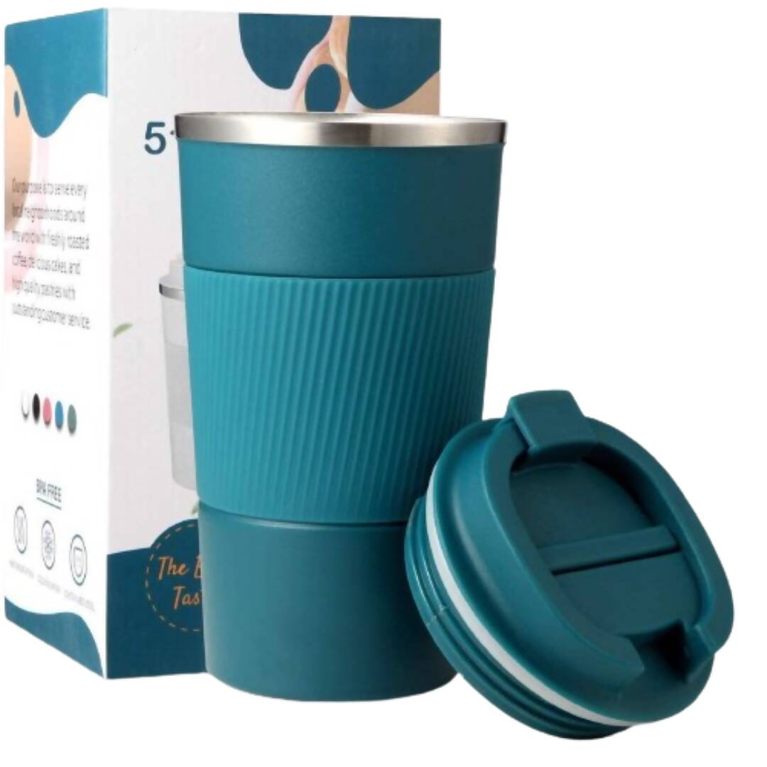 Teal travel mug with a lid next to its packaging on a white background
