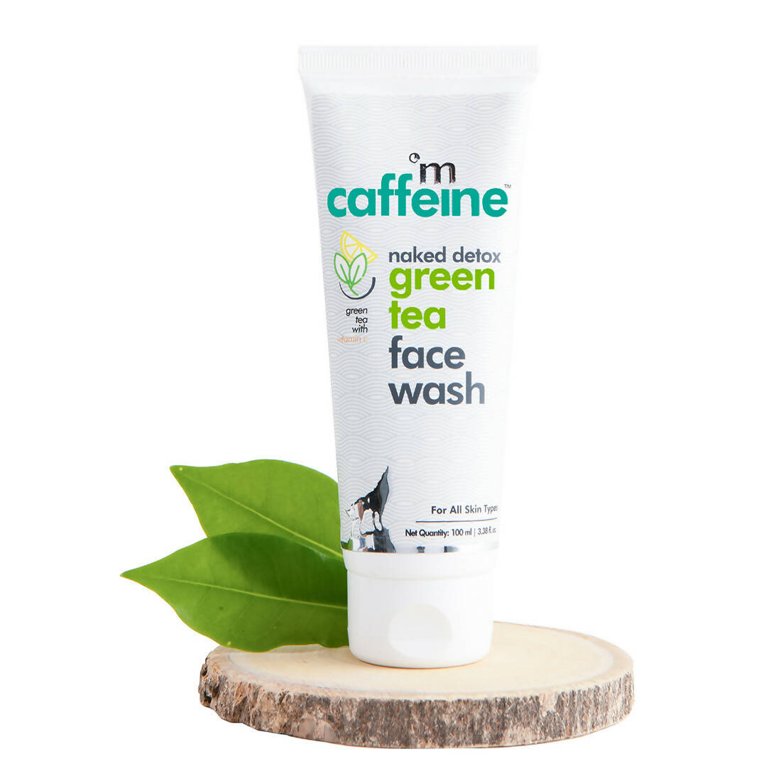 Tube of 'm caffeine green tea face wash with green leaves on a wooden block