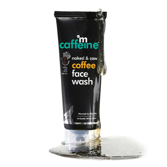 Black tube of 'm caffeine naked & raw coffee face wash' on a clear stand with a white background